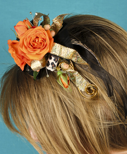 This fun orange headpiece features fun orange flowers with gold & leopard print ribbon. Such a fun added detail to any prom dress.
